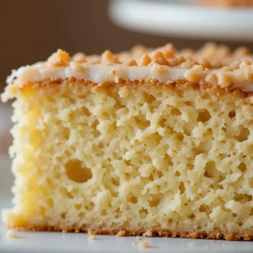 Moist kefir sheet cake topped with powdered sugar on a wooden table.